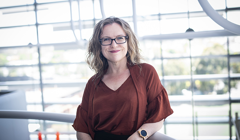 Melissa Davis photographed standing in front of a window