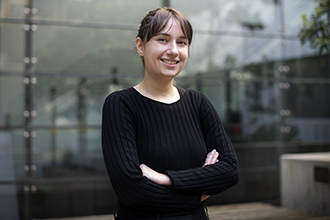 Researcher with crossed arms, smiling at camera