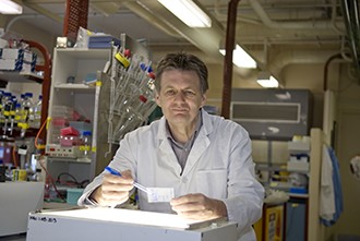 Professor Alan Cowman in a laboratory looking at a protein blot over a lightbox