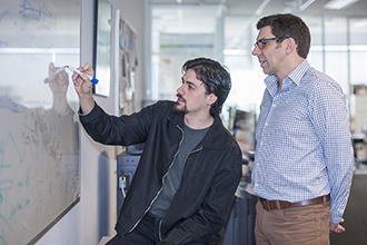 Two researchers drawing on whiteboard