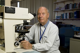 Professor Don Metcalf in front of a microscope