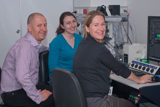 Doug Hilton, Kathy Potts and Kelly Rogers in front of a microscope