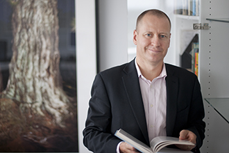 Professor Doug Hilton standing in front of a painting