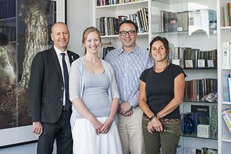 Institute director and scientist with two supporters