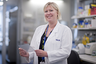 Dr Emma Josefsson holding a Western Blot in a lab