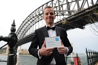 Dr Greg Ebert with his award under the Sydney Harbour Bridge