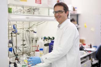 Dr Guillaume Lessene standing in front of a fume hood in a laboratory