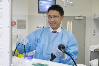 Dr Jason Tye-Din holding diagnostic equipment in a laboratory