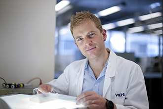 Dr Justin Boddey in a laboratory with a light box