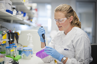 Dr Kirsten Fairfax pipetting in the laboratory