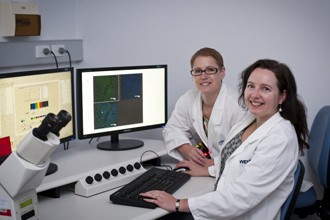 Dr Kylie Mason and Dr Lorraine O'Reilly in front of a computer