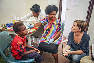 Doctor and nurse testing child for malaria in Papua New Guinea