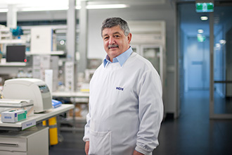 Professor Nick Nicola stands in lab smiling