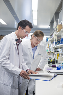 Researchers looking at notebook in the laboratory