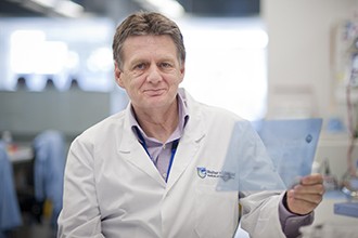 Alan Cowman looking at gel photo in lab