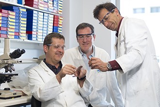 Dr Michael Buchert, Dr Toby Phesse, Associate Professor Matthias Ernst looking at gel photo