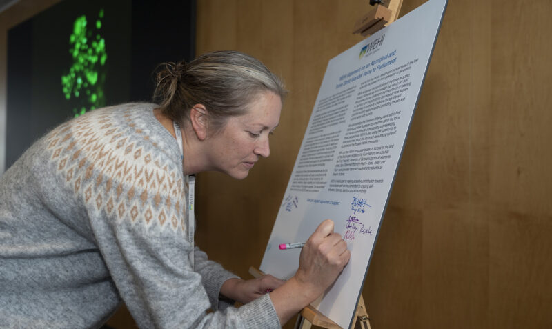 Female staff member signing the statement of support for a