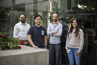 Four researchers standing in a courtyard