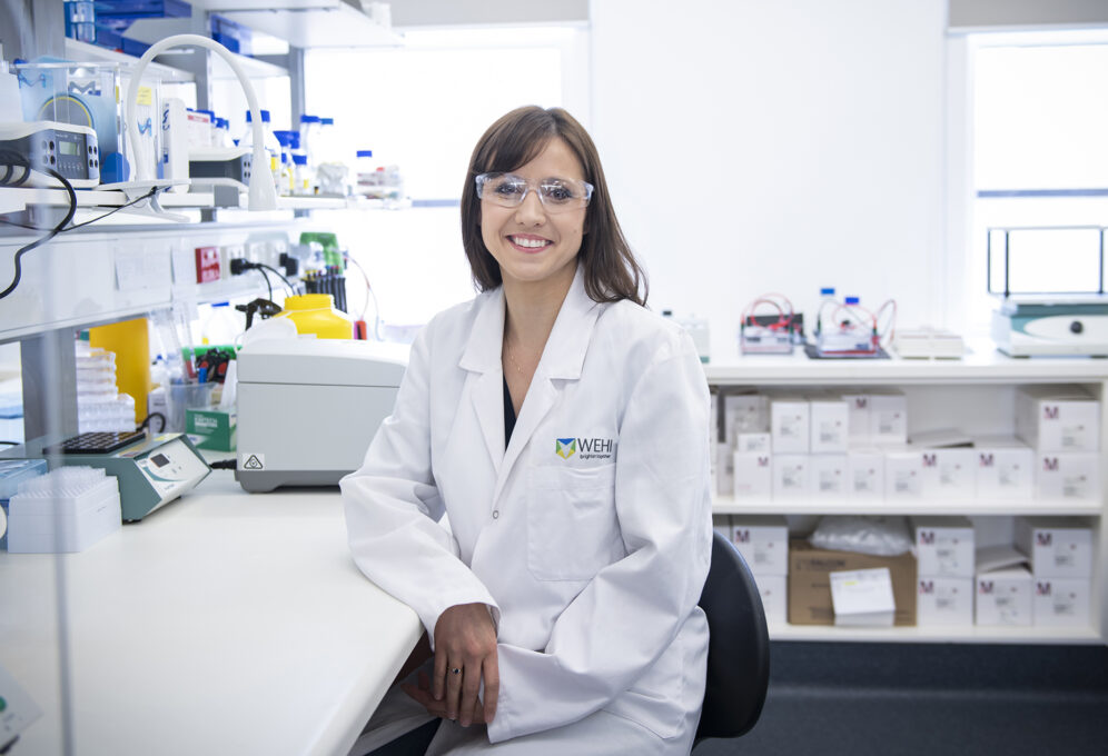 Dr Bekky Feltham sitting at a laboratory bench