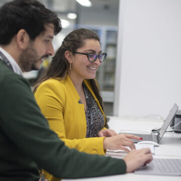 Two members of the clinical research project team sitting at their computer desks
