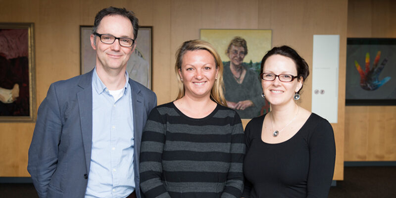 A man and two women standing side by side