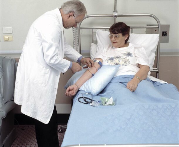 Len Harrison taking a blood sample from a patient