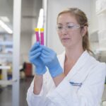 Dr Tracy Putoczki inspecting two test samples