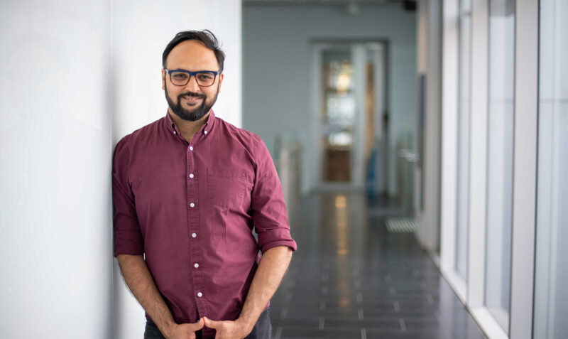 Associate Professor Shalin Naik standing against a wall