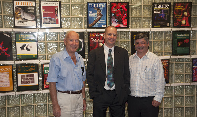 Professor Don Metcalf, Professor Doug Hilton and Professor Nick Nicola standing in front of shelves with journal covers