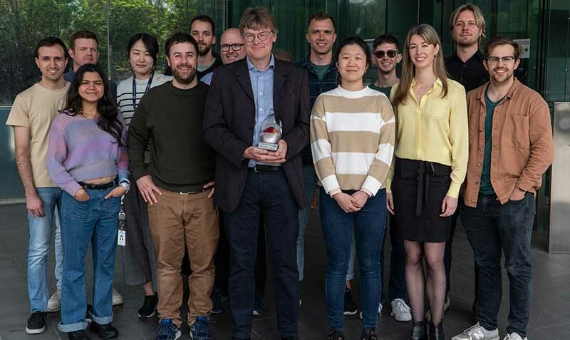 David Komander holding his award and surrounded by his ubiquitin team