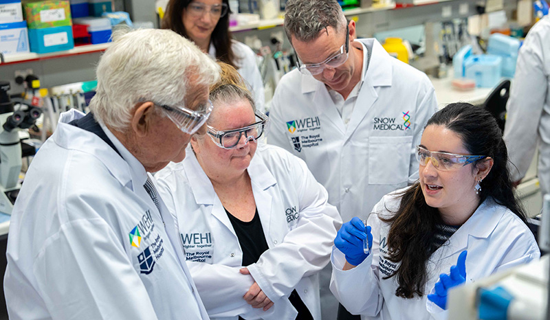 Guests and researchers are photographed talking in a laboratory