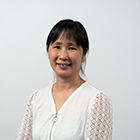 Ellen Tsui posing for a portrait wearing a white long sleeve blouse