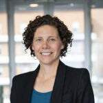 Head-and-shoulders photo of Dr Victoria Jameson in a light-filled hallway