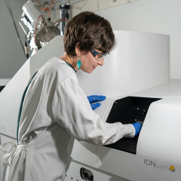 A scientist is photographed using the MIBIscope proteomic technology