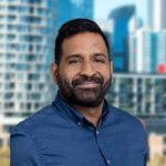 Portrait photo of Heshan Peiris with a cityscape in the background