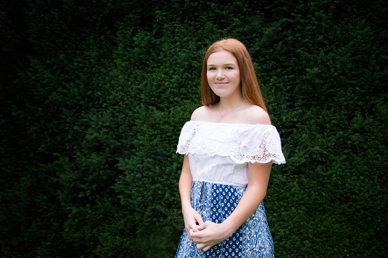 Lauren photographed against a dark garden backdrop