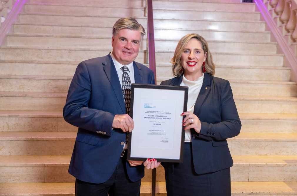Photo of Professor Ken Smith and Professor Misty Jenkins AO side by side, holding a framed certificate