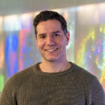 Photo of Michael Lazarou with a colourful background